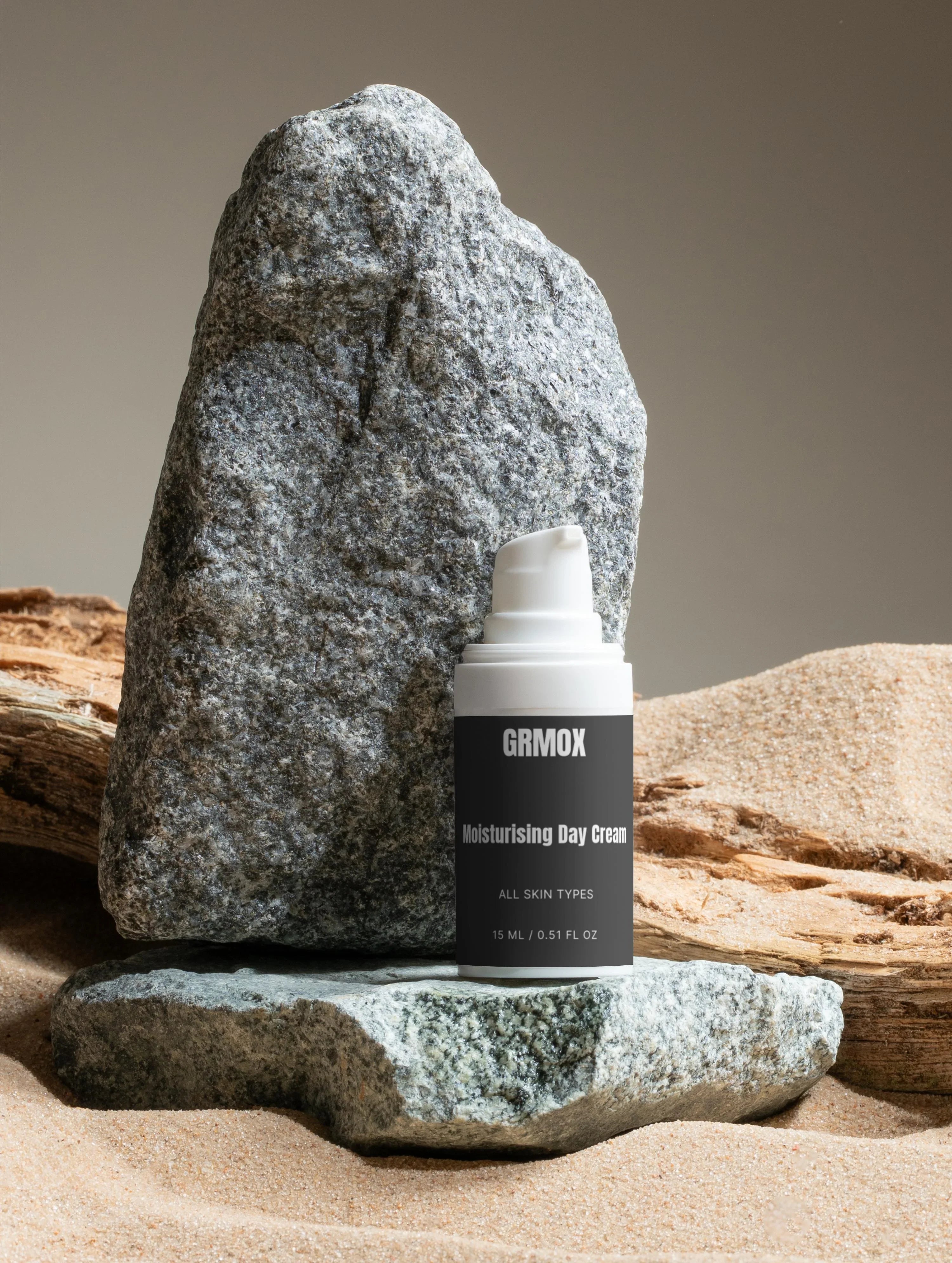 GRMOX Moisturising Day Cream for all skin types, 15ml, displayed on rocks with sand background