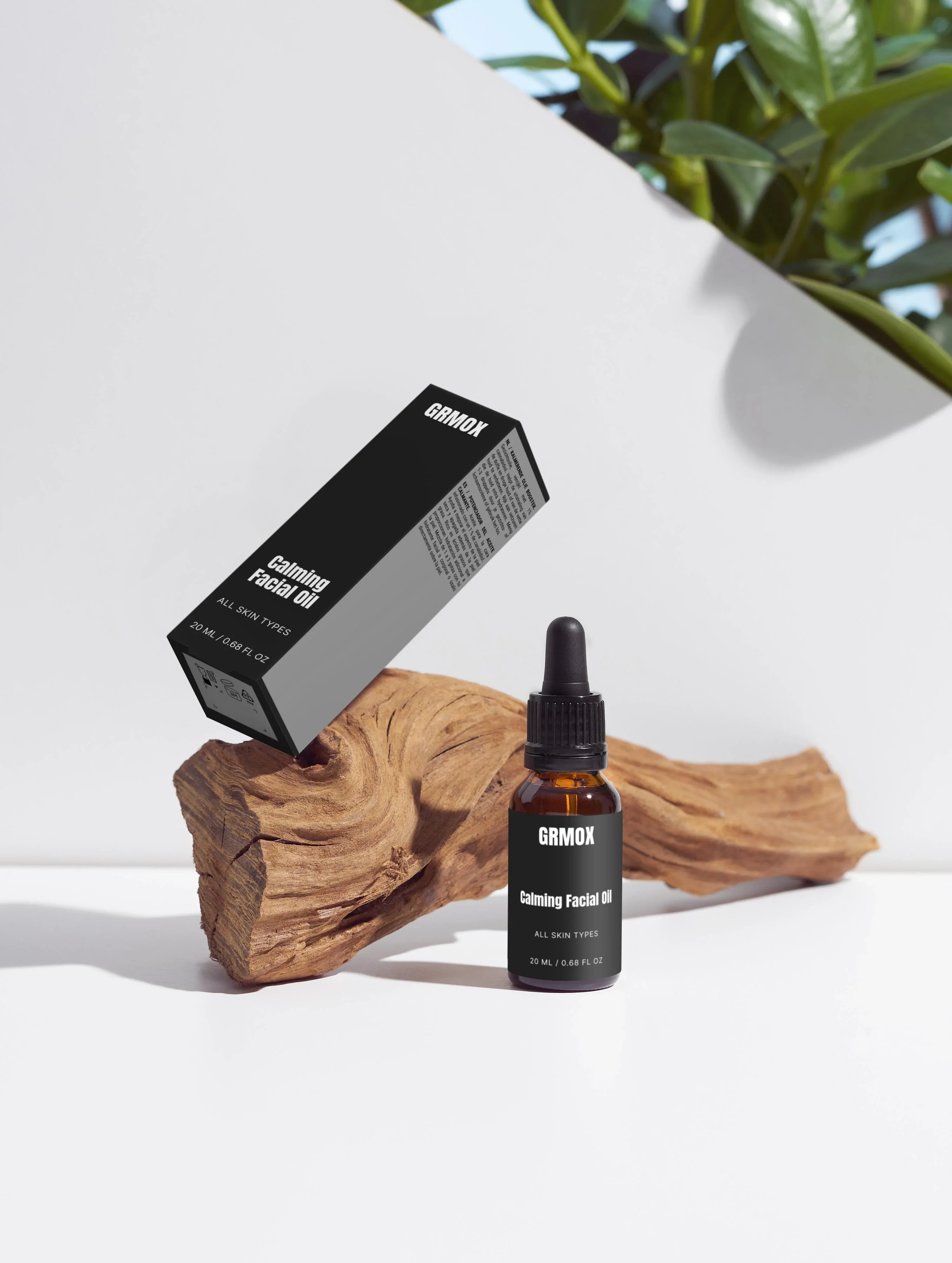 GRMOX Calming Facial Oil for all skin types, 20ml bottle with dropper and packaging on wood, green plant background