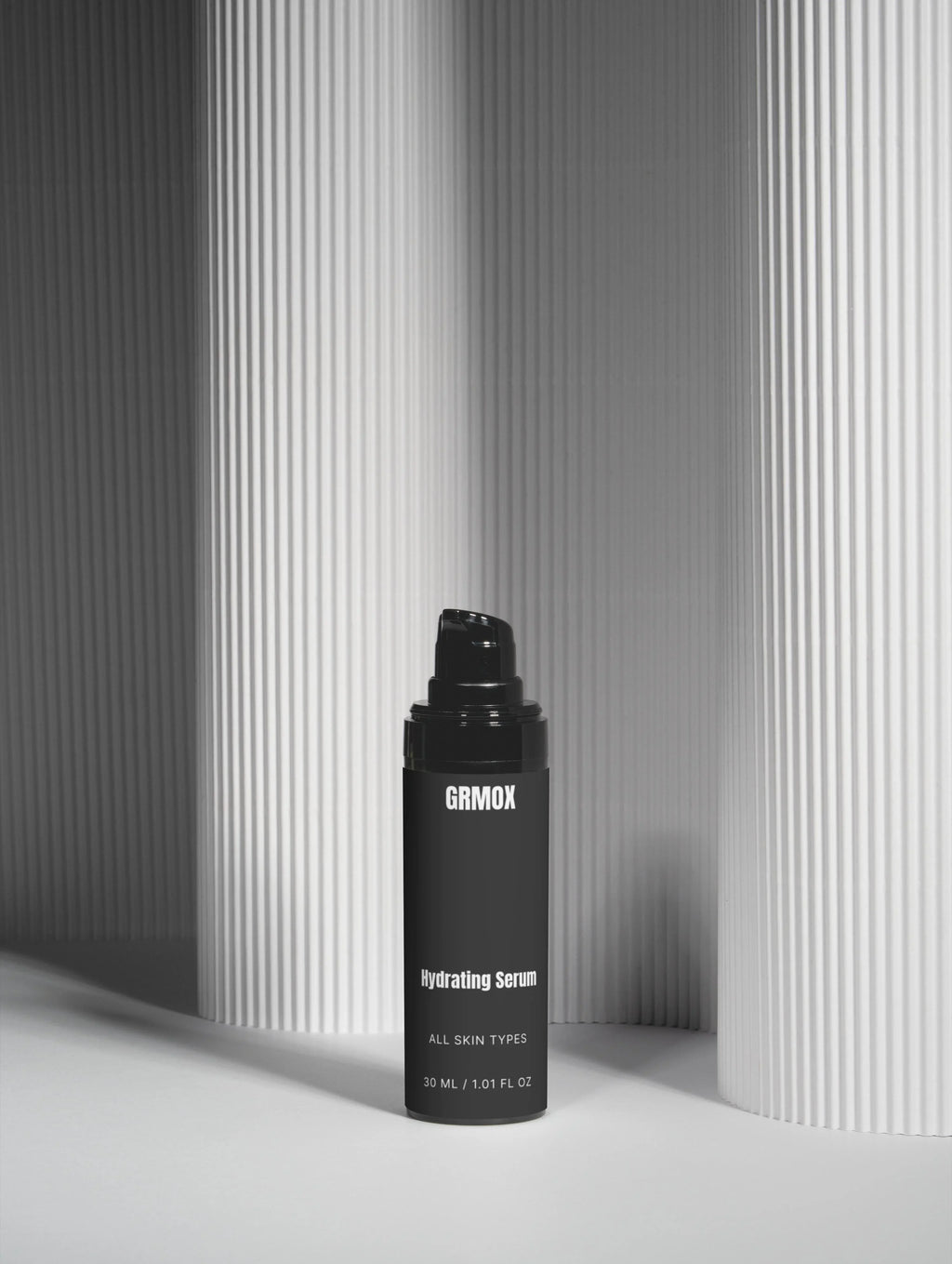 GRMOX Hydrating Serum for all skin types, 30ml bottle against minimalist striped background