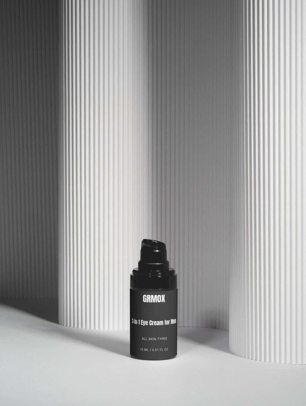 GRMOX 3-in-1 Eye Cream for Men, all skin types, 15ml black bottle against minimalist striped background
