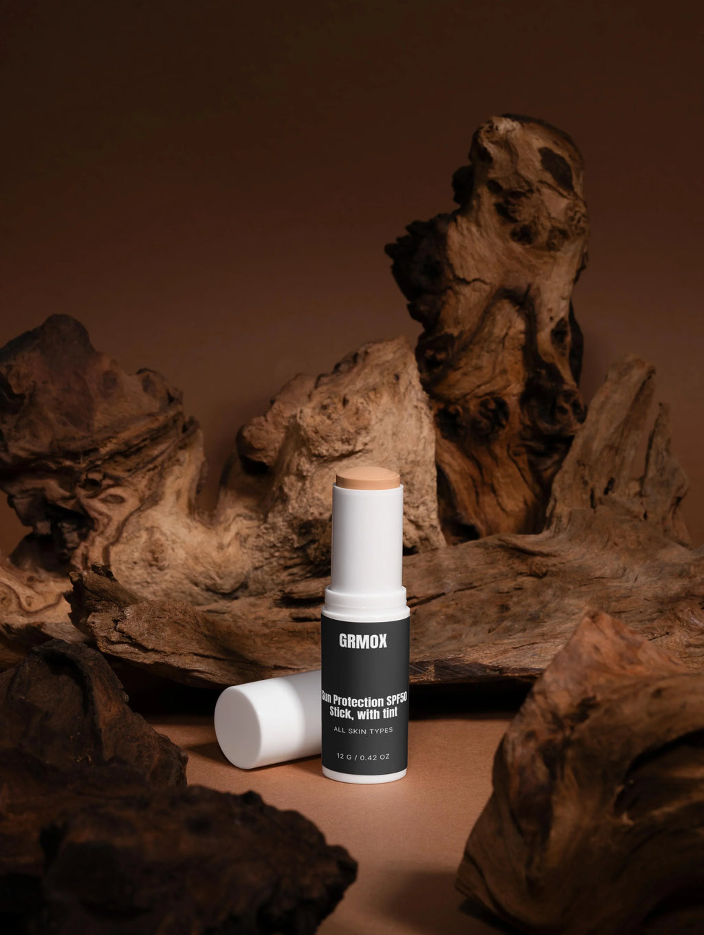GRMOX Sun Protection SPF50 Stick with tint for all skin types, displayed on rustic wood background