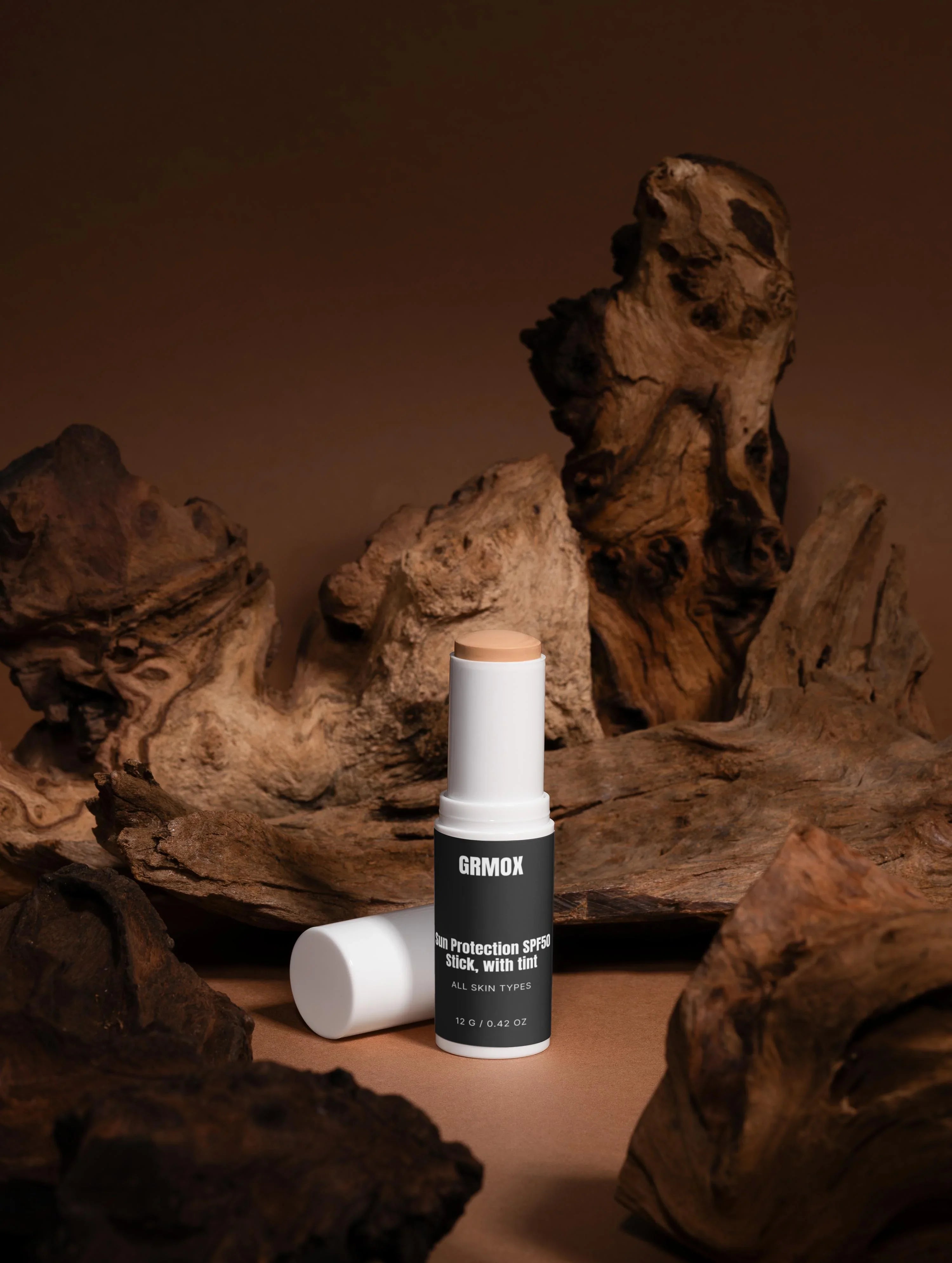 GRMOX Sun Protection SPF50 Stick with tint for all skin types, displayed on rustic wood background