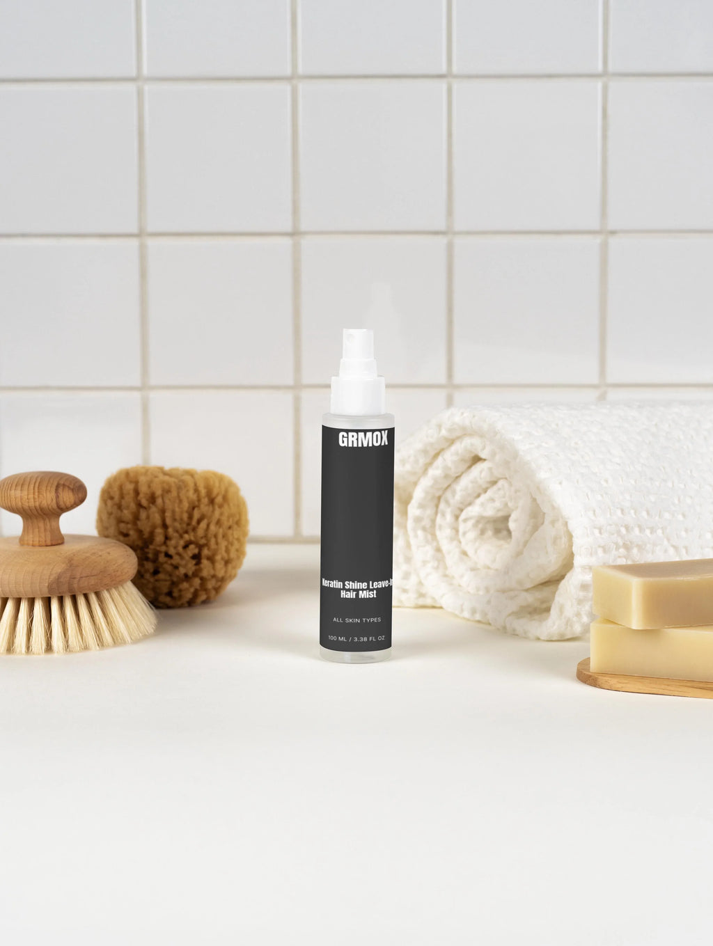 Keratin Shine Leave-In Hair Mist for all skin types, displayed with bath accessories on a tiled countertop