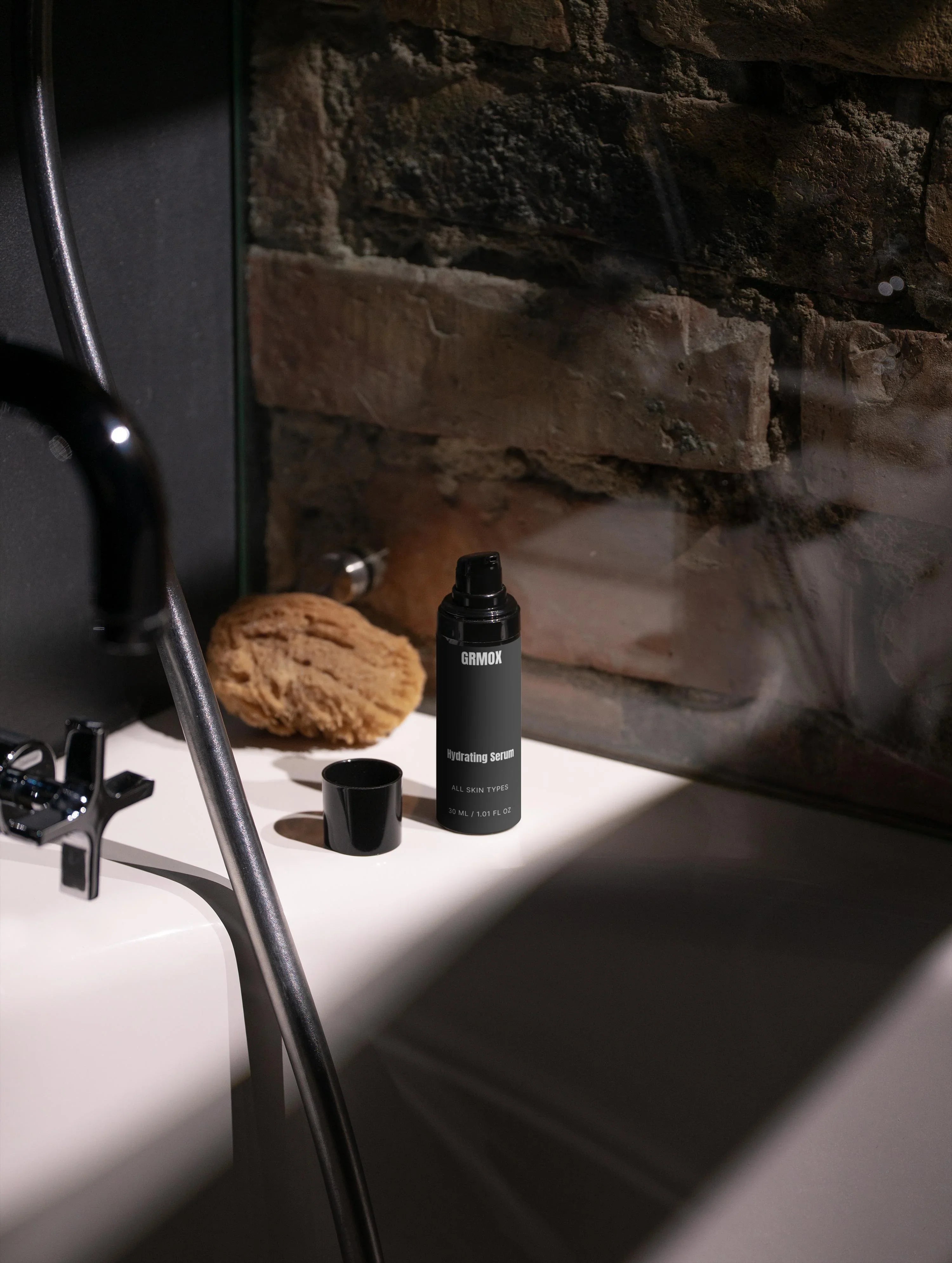 GRMOX Hydrating Serum for all skin types on bathroom counter with natural sponge and black fixtures