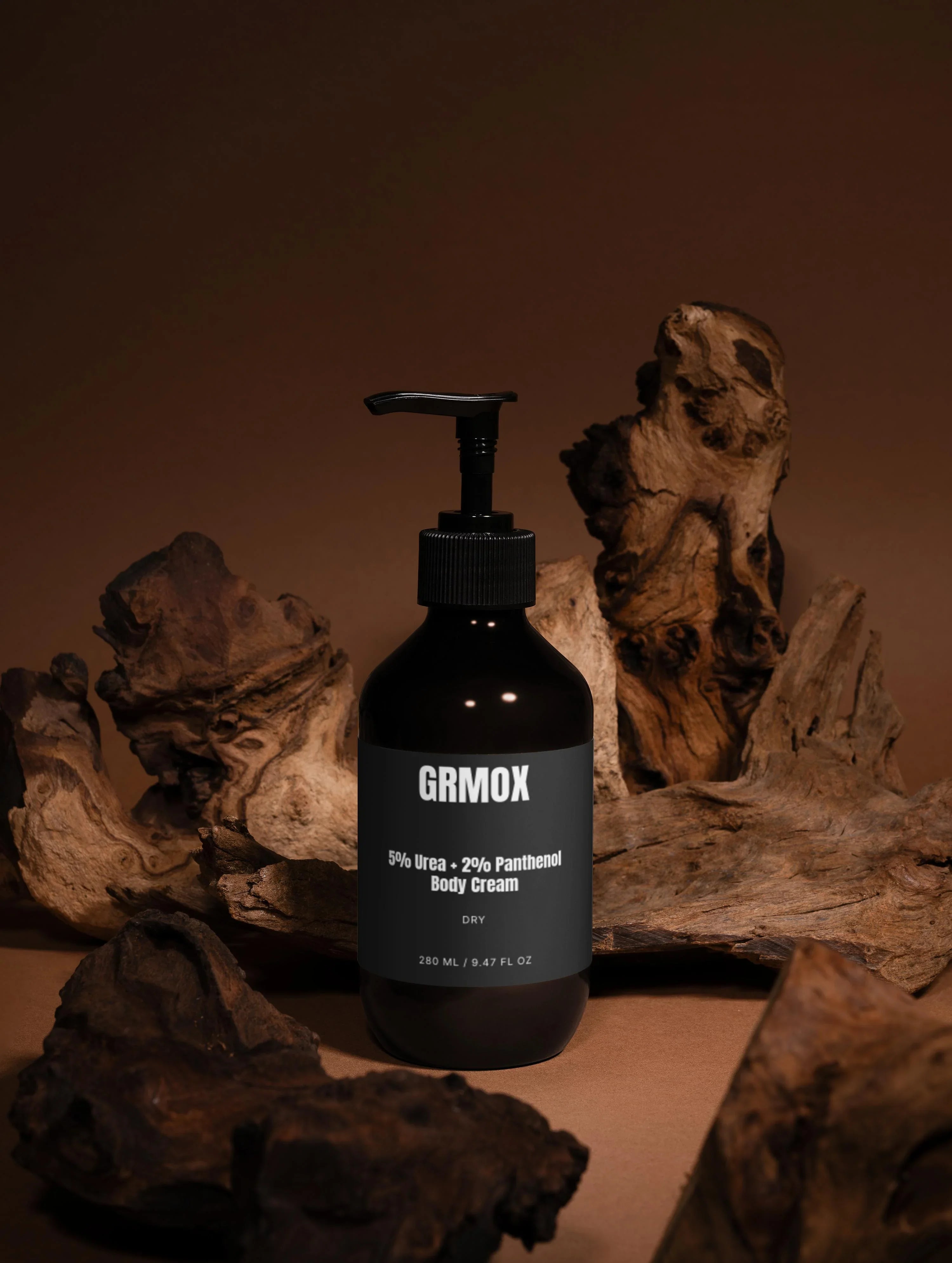 GRMOX 5% Urea + 2% Panthenol Body Cream for dry skin, 280ml, in sleek black bottle with pump, styled with rustic driftwood.