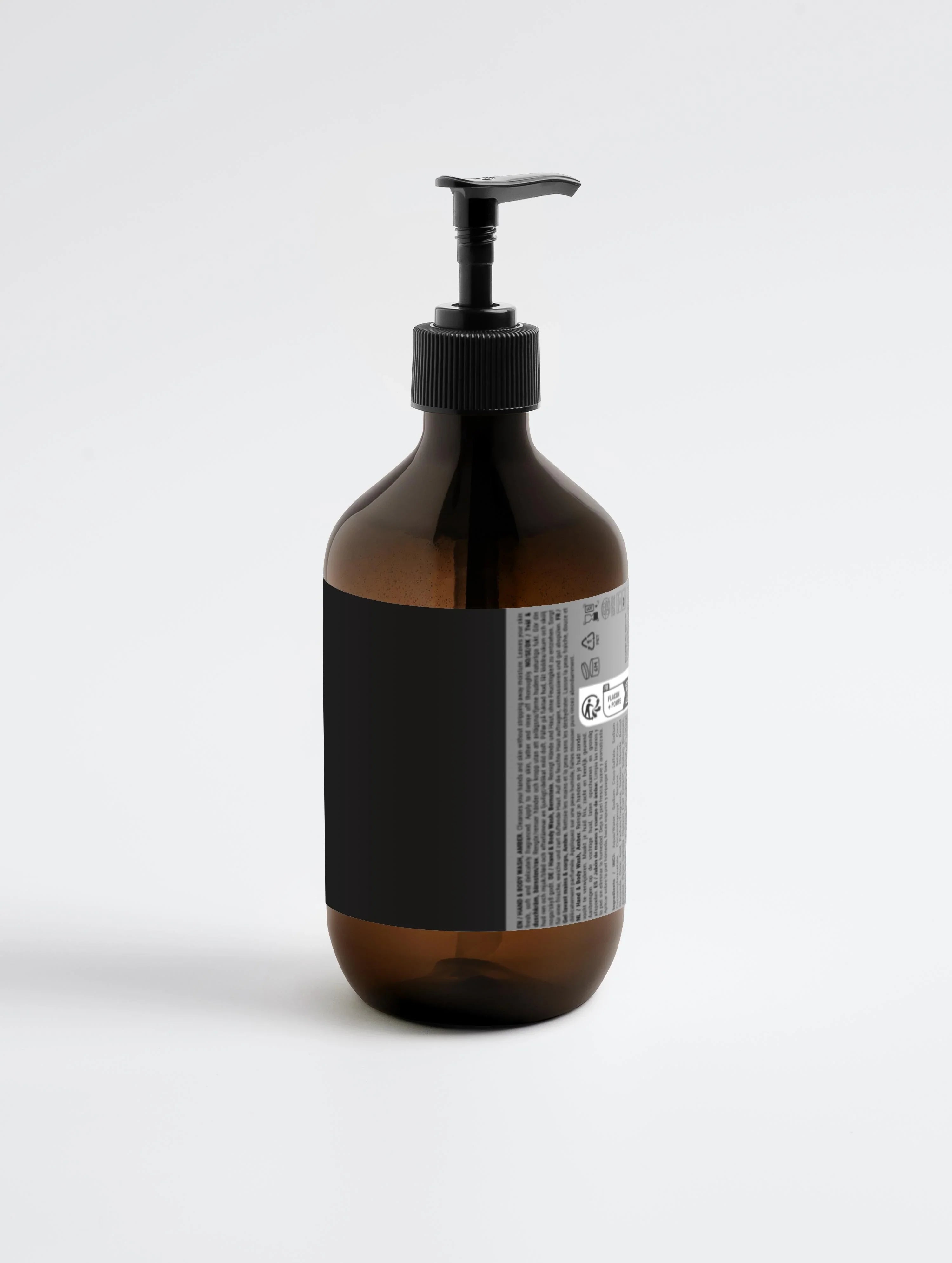 Amber glass bottle with black pump dispenser, labeled hand and body wash, minimalist design