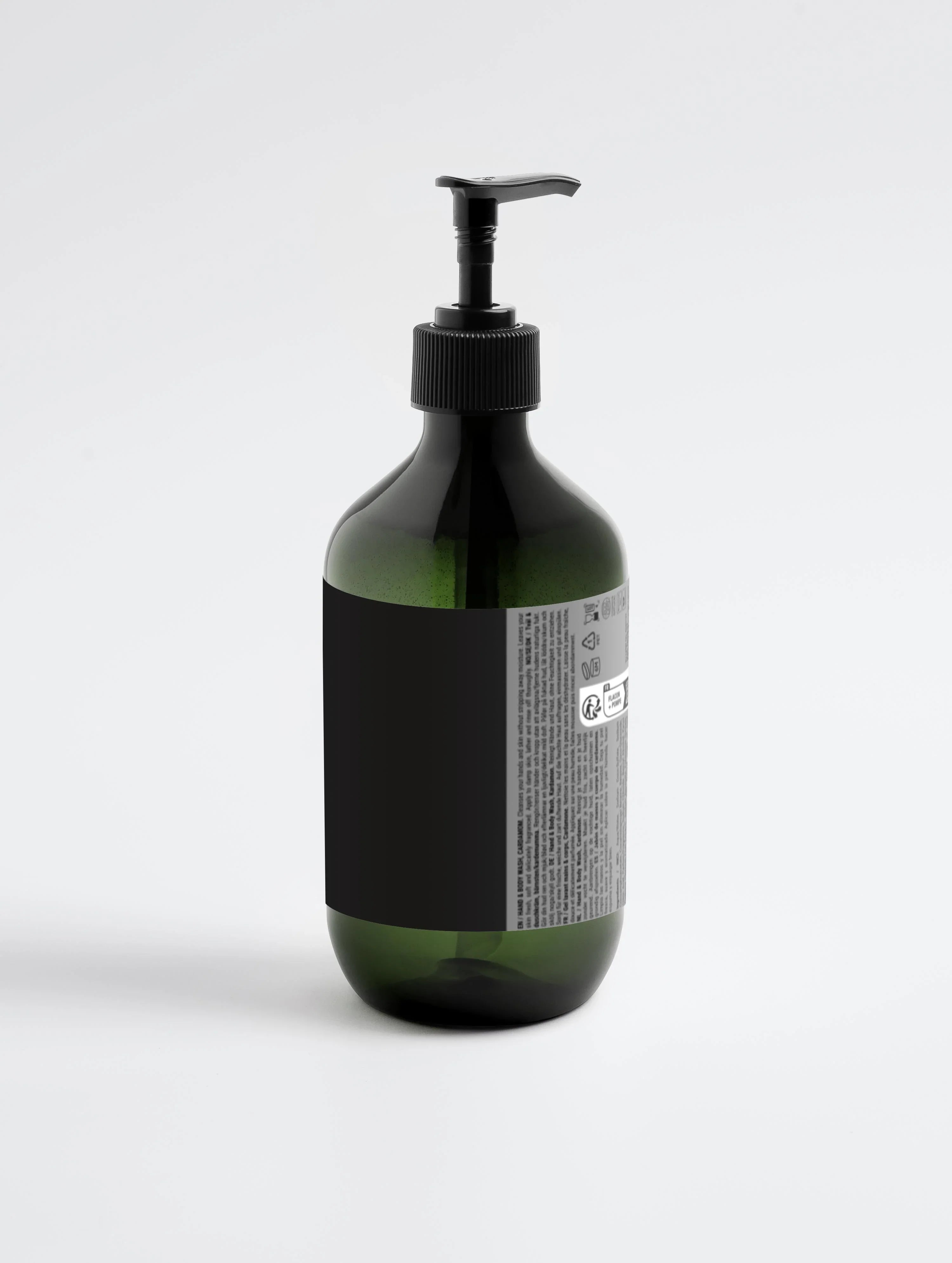 Green glass bottle with black pump dispenser, labeled hand and body wash, minimalist design