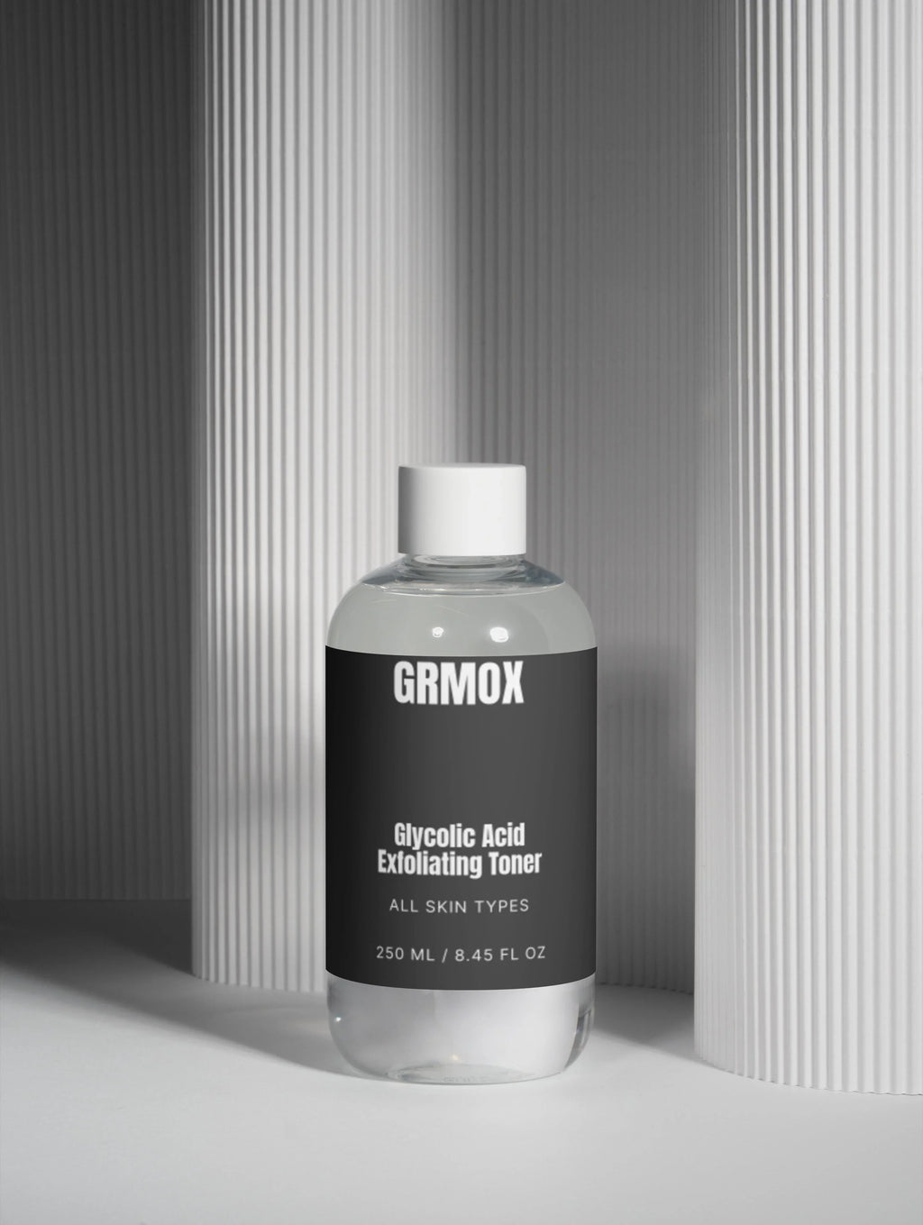 GRMOX Glycolic Acid Exfoliating Toner for all skin types, 250ml bottle against modern striped backdrop