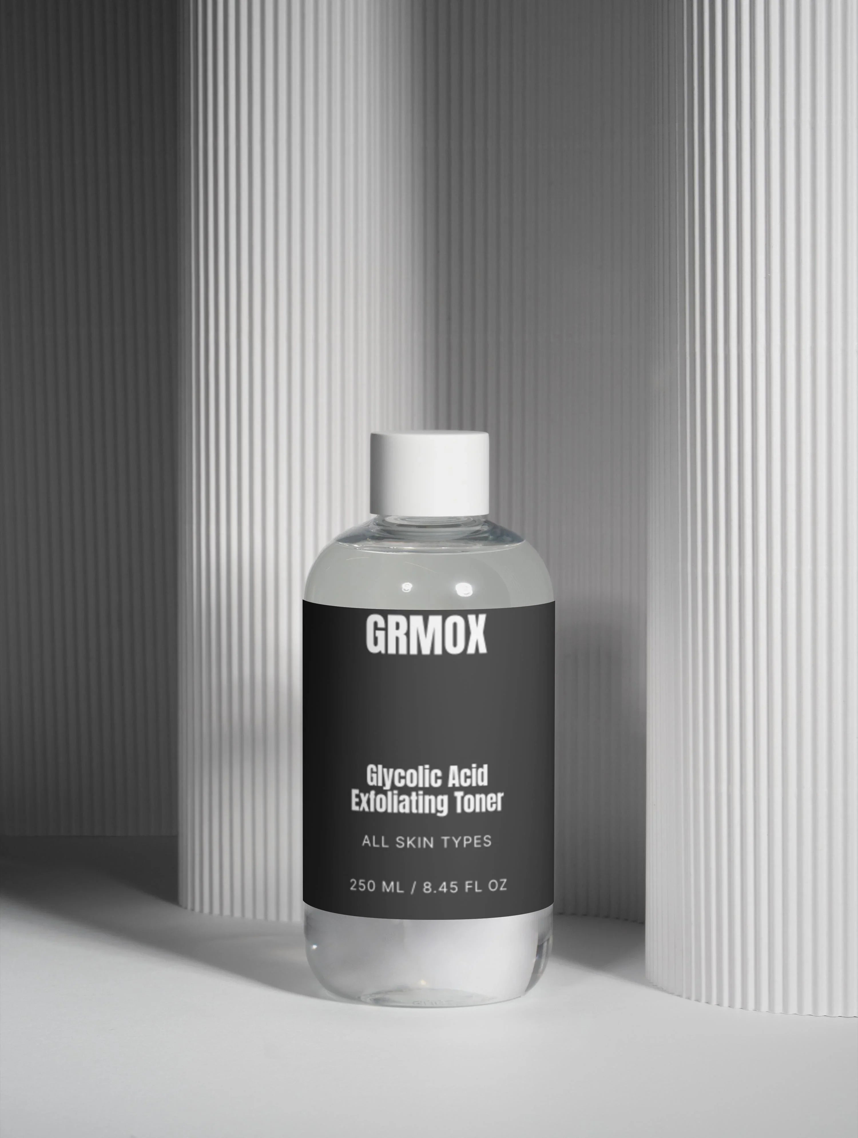 GRMOX Glycolic Acid Exfoliating Toner for all skin types, 250ml bottle against modern striped backdrop