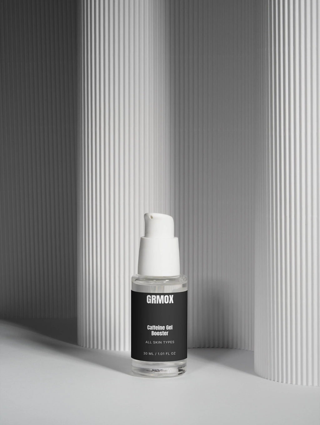 GRMOX Caffeine Gel Booster for all skin types, 30ml clear bottle with white pump against modern striped backdrop