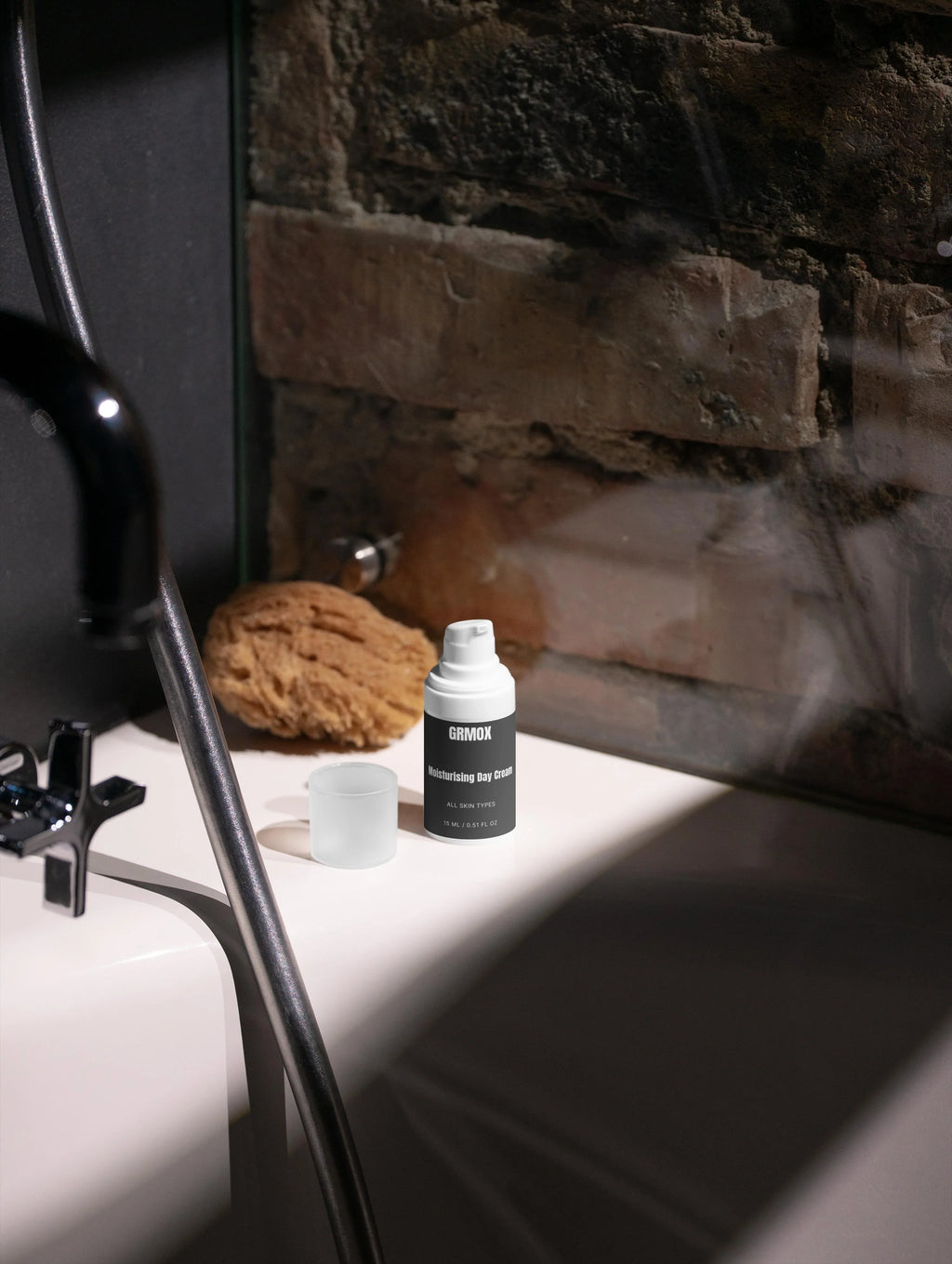 GRMOX Moisturising Day Cream for all skin types on bathroom counter with sponge and brick wall