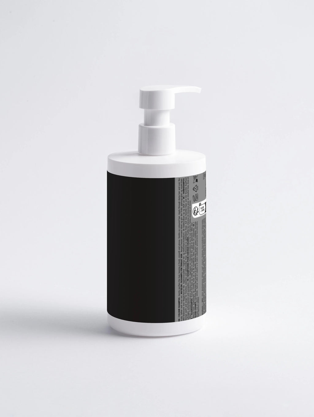 White pump bottle with black label, featuring multilingual text and usage icons for hair care product