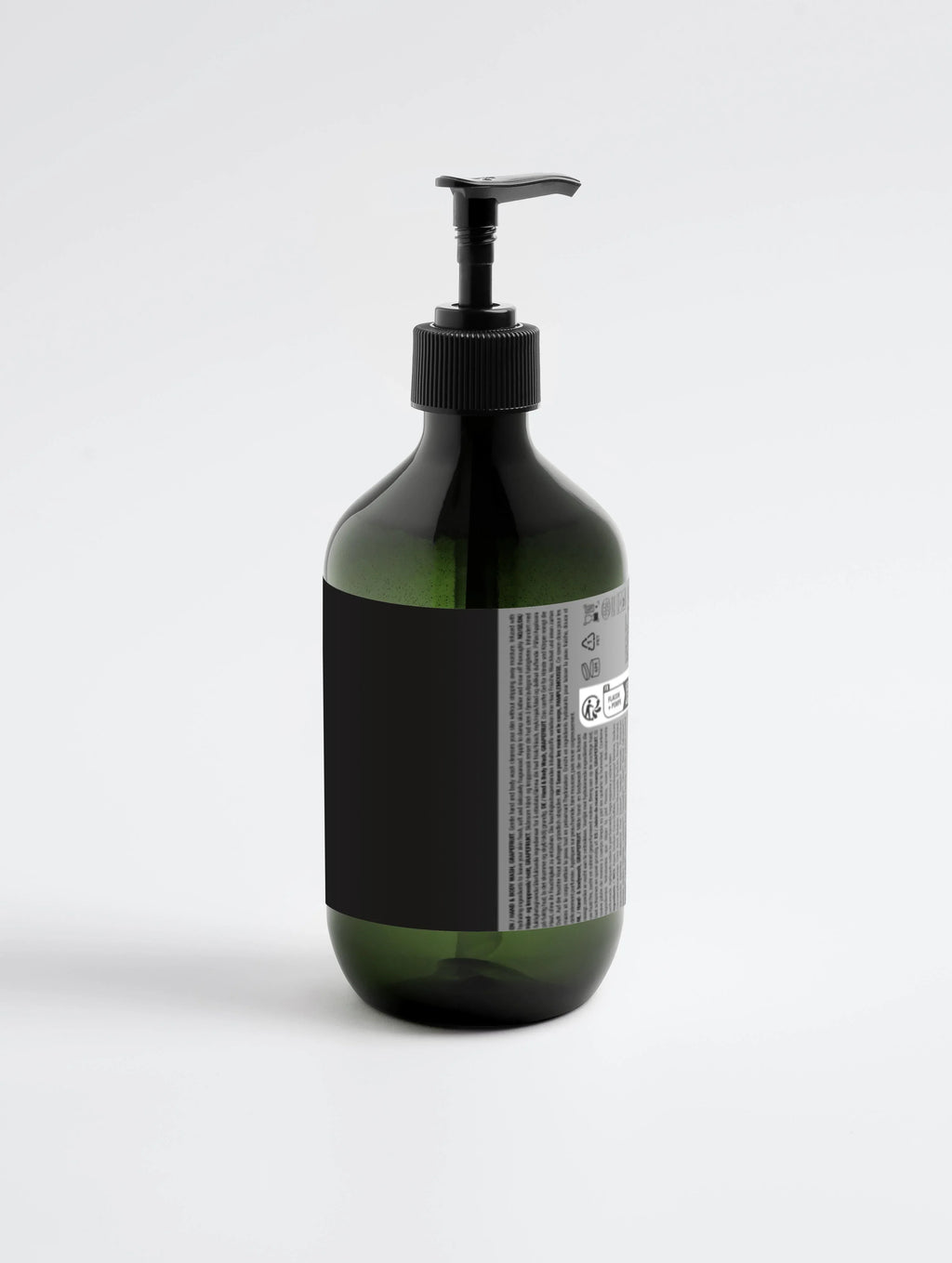 Green glass bottle with black pump dispenser, ideal for hand and body wash, featuring minimalist label design.