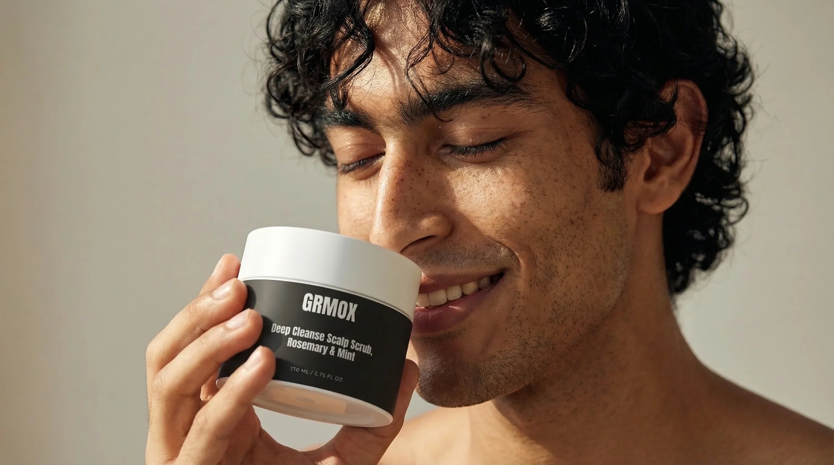 Man holding GRMOX Deep Cleanse Scalp Scrub with Rosemary & Mint, enjoying fresh scent