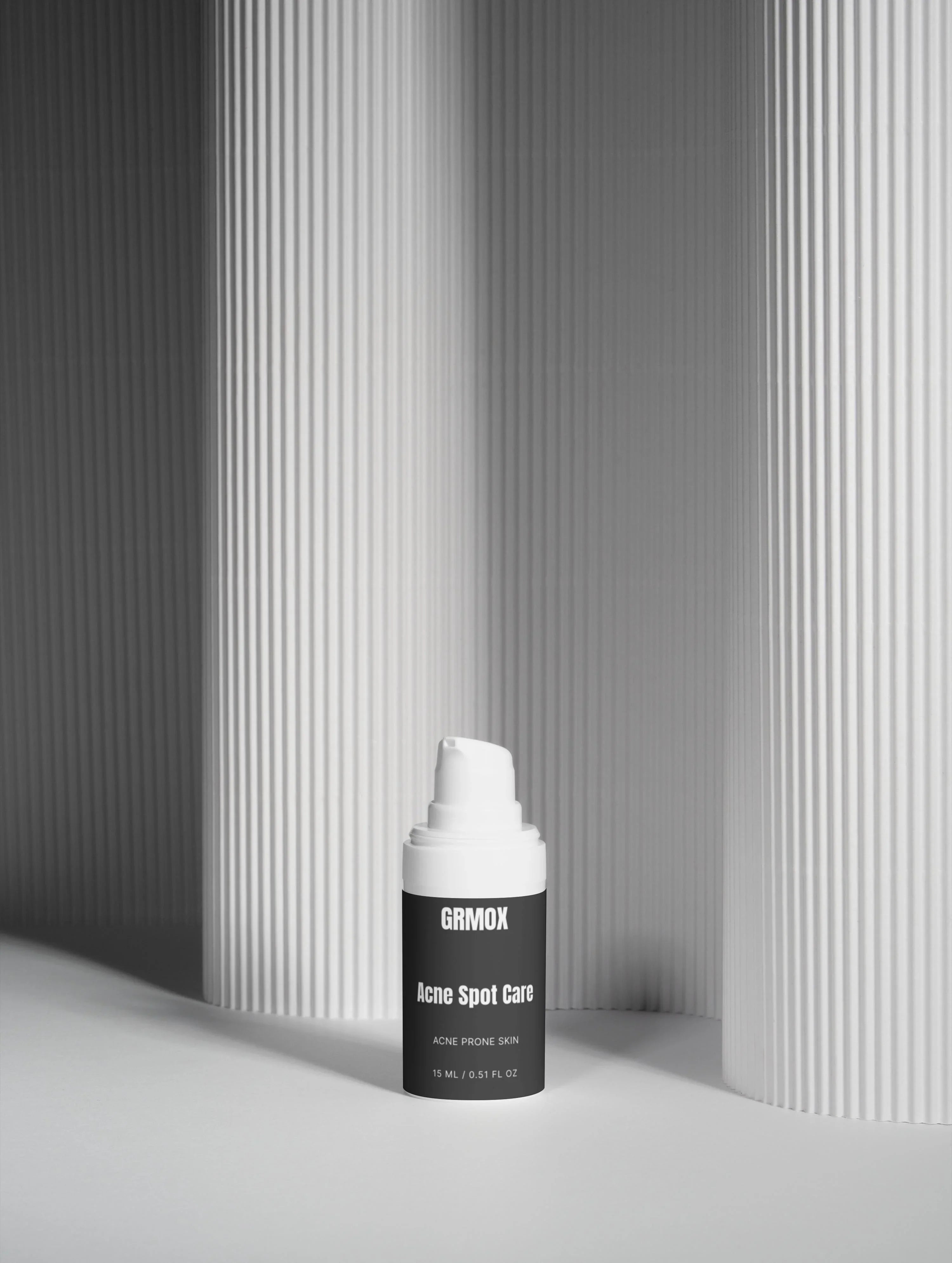 GRMOX Acne Spot Care for acne prone skin, 15ml bottle with white pump against minimalist striped background