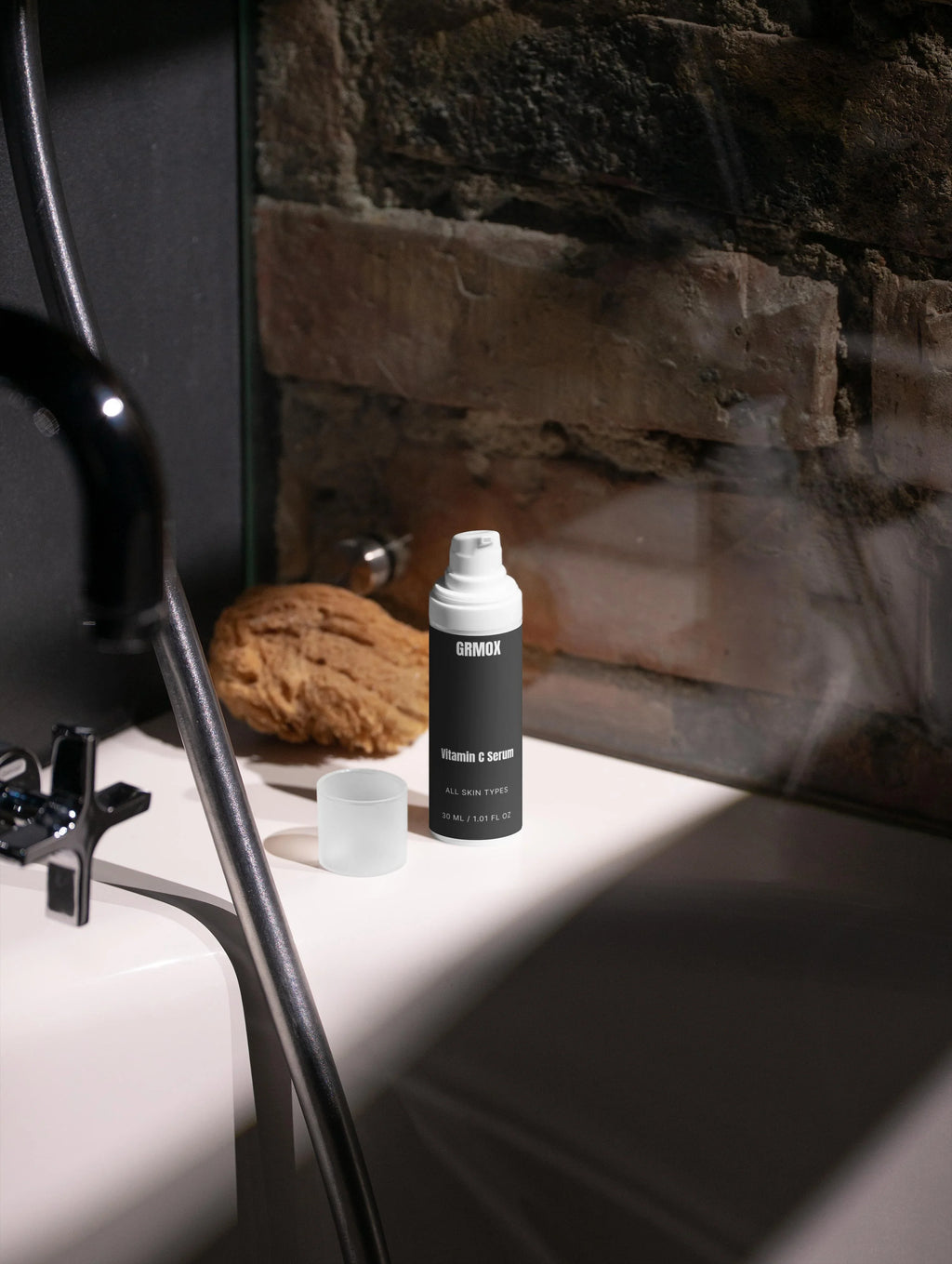 GRMOX Vitamin C Serum for all skin types on bathroom counter with natural sponge and modern fixtures