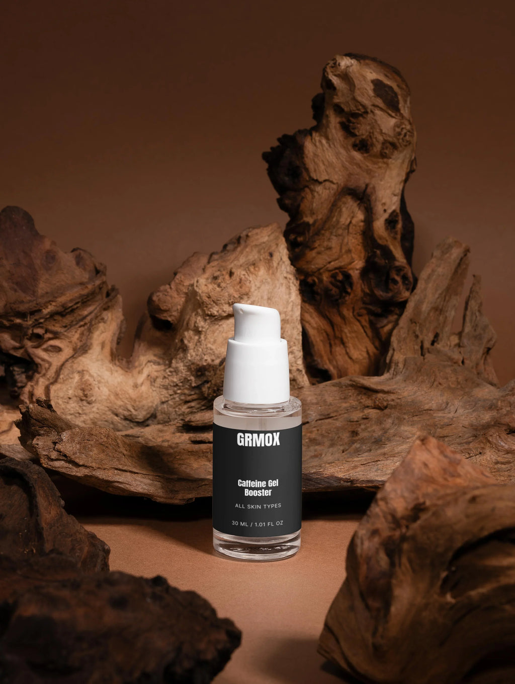 GRMOX Caffeine Gel Booster for all skin types, 30ml bottle with pump, displayed on rustic driftwood