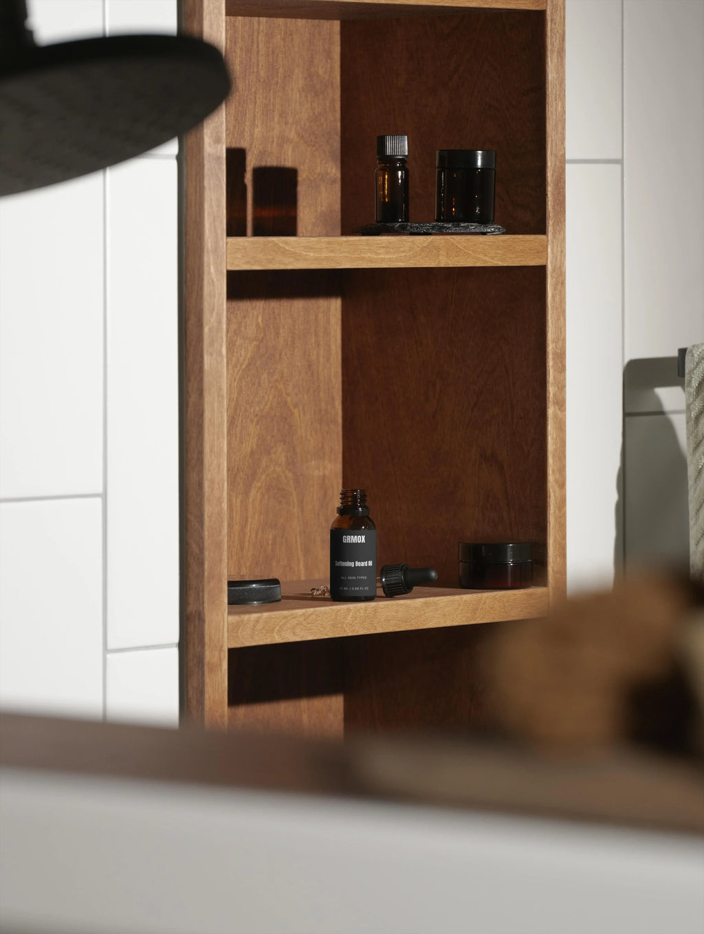 GRMOX Softening Beard Oil bottle on wooden shelf with grooming products in bathroom