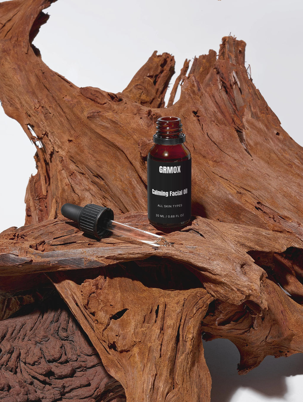 GRMOX Calming Facial Oil for all skin types, 20ml, in amber glass bottle with dropper on rustic wood