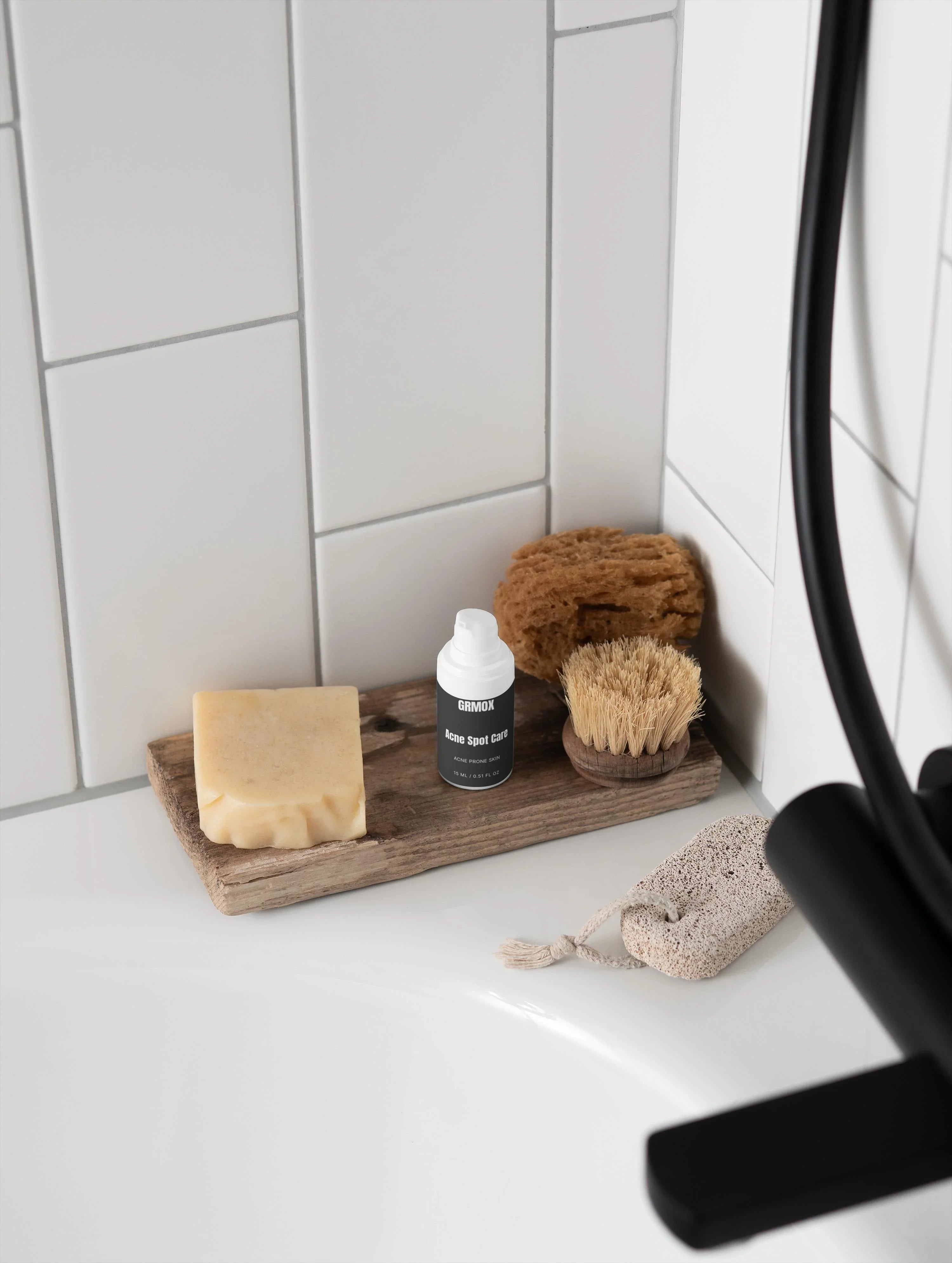 Acne Spot Care serum for acne prone skin on wooden tray with soap, brush, and sponge in bathroom