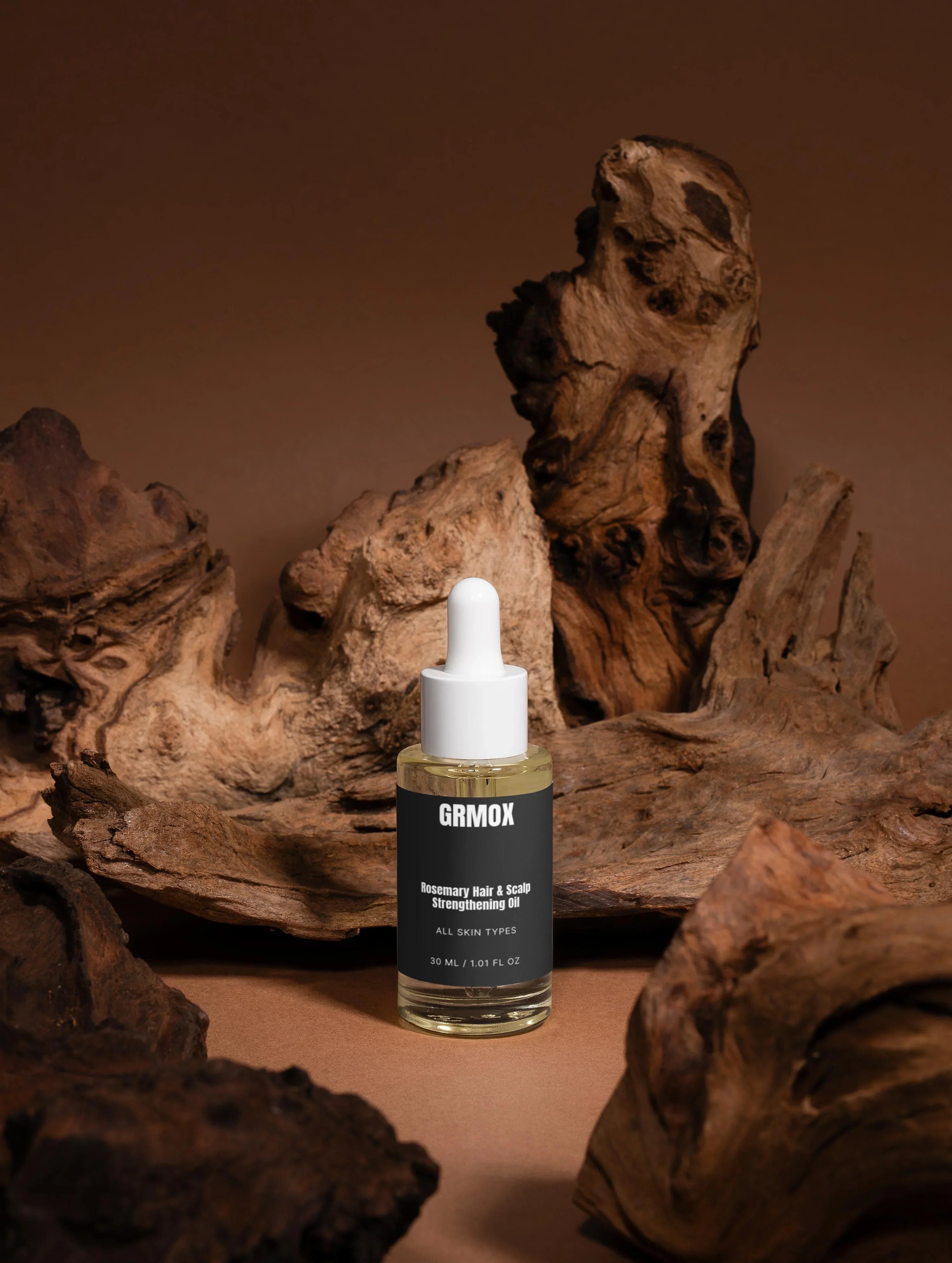 GRMOX Rosemary Hair & Scalp Strengthening Oil for all skin types, 30ml bottle with dropper on rustic wood background