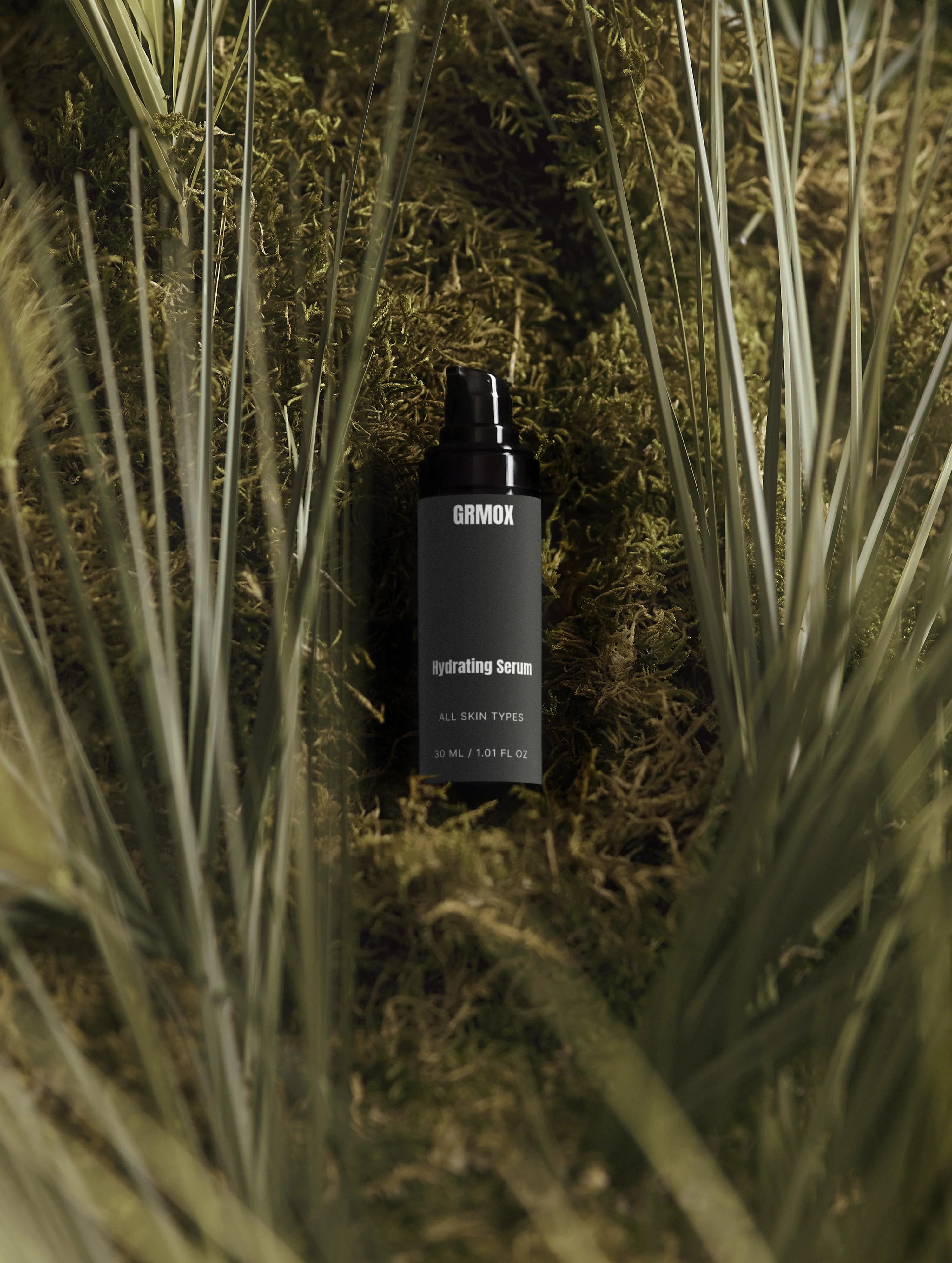 GRMOX Hydrating Serum for all skin types, nestled in mossy greenery, 30ml bottle with pump dispenser