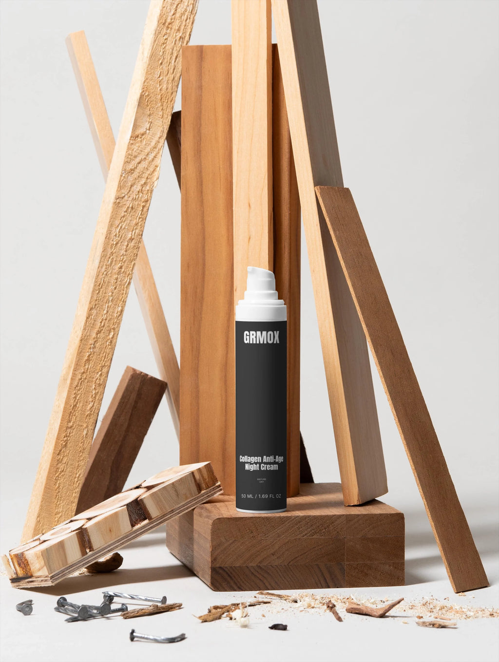 GRMOX Collagen Anti-Age Night Cream in black bottle with wooden backdrop, nails, and shavings