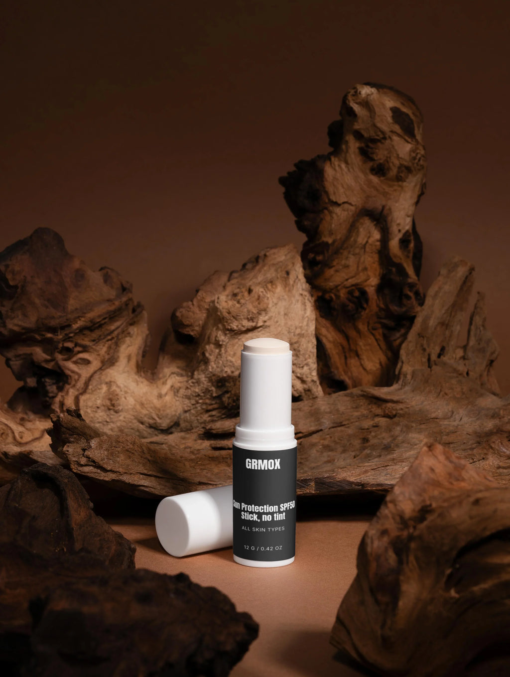 GRMOX Sun Protection SPF50 Stick, no tint for all skin types, displayed on rustic wood background