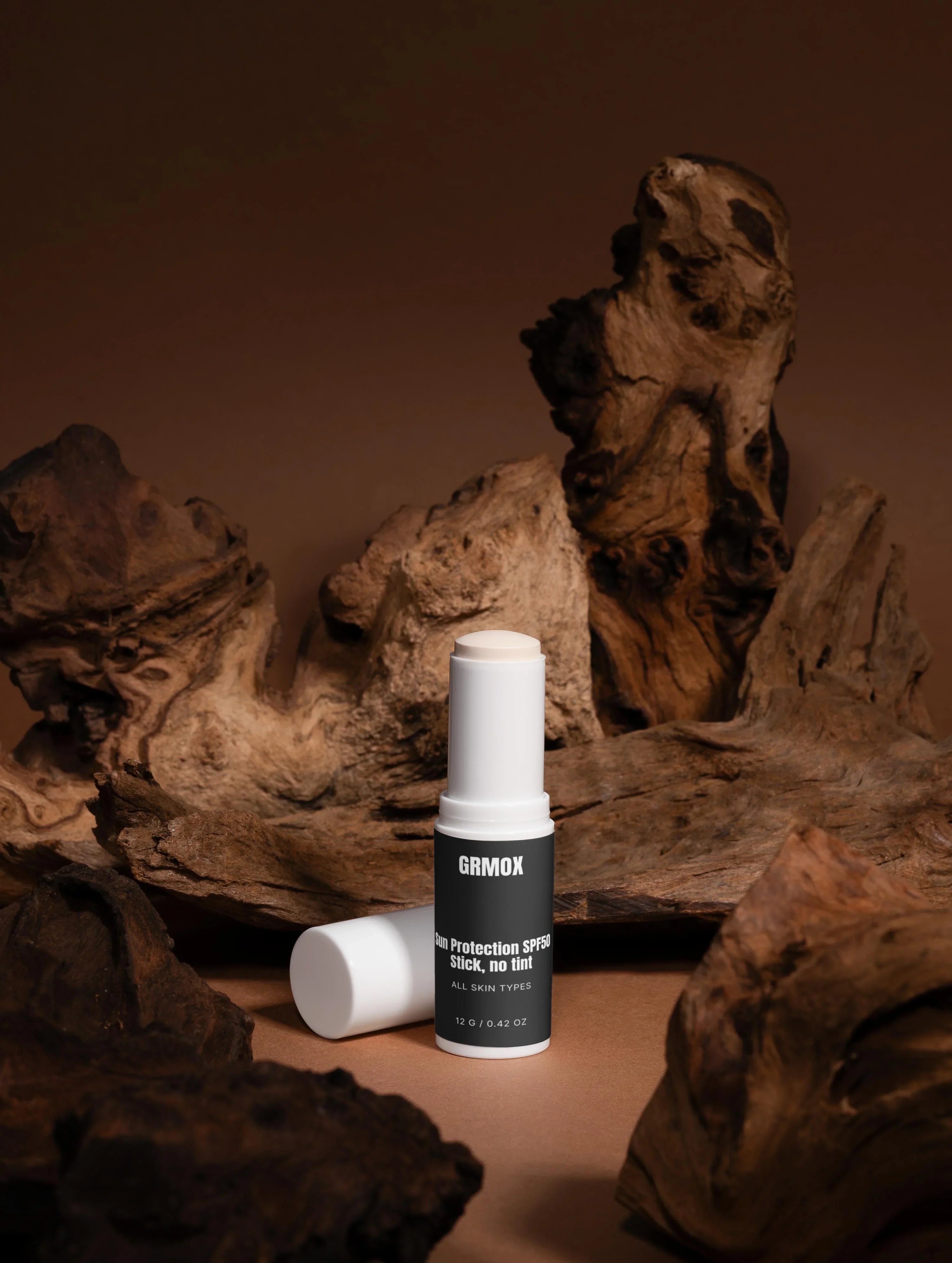 GRMOX Sun Protection SPF50 Stick, no tint for all skin types, displayed on rustic wood background