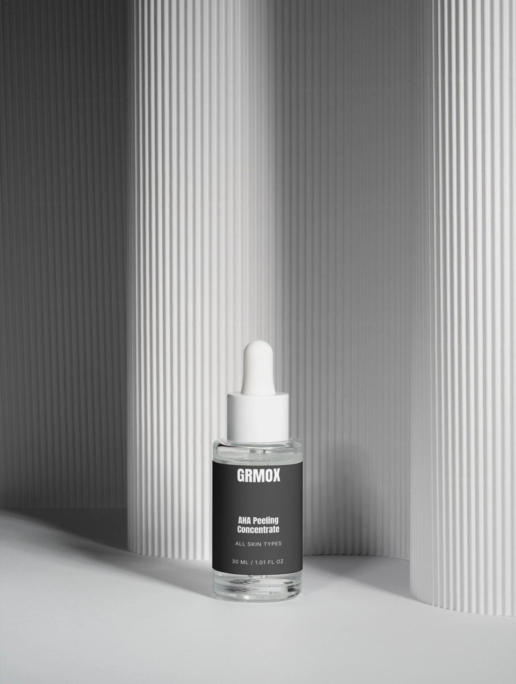 GRMOX AHA Peeling Concentrate for all skin types, 30ml glass dropper bottle against minimalist striped backdrop