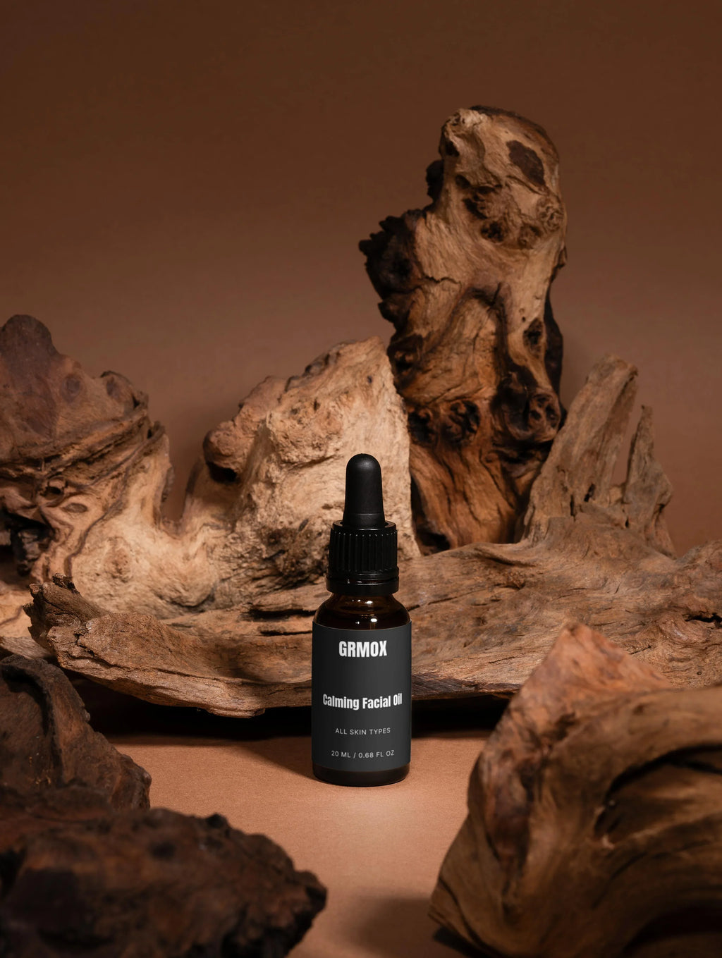 GRMOX Calming Facial Oil for all skin types, 20ml bottle with dropper, displayed on rustic wood background