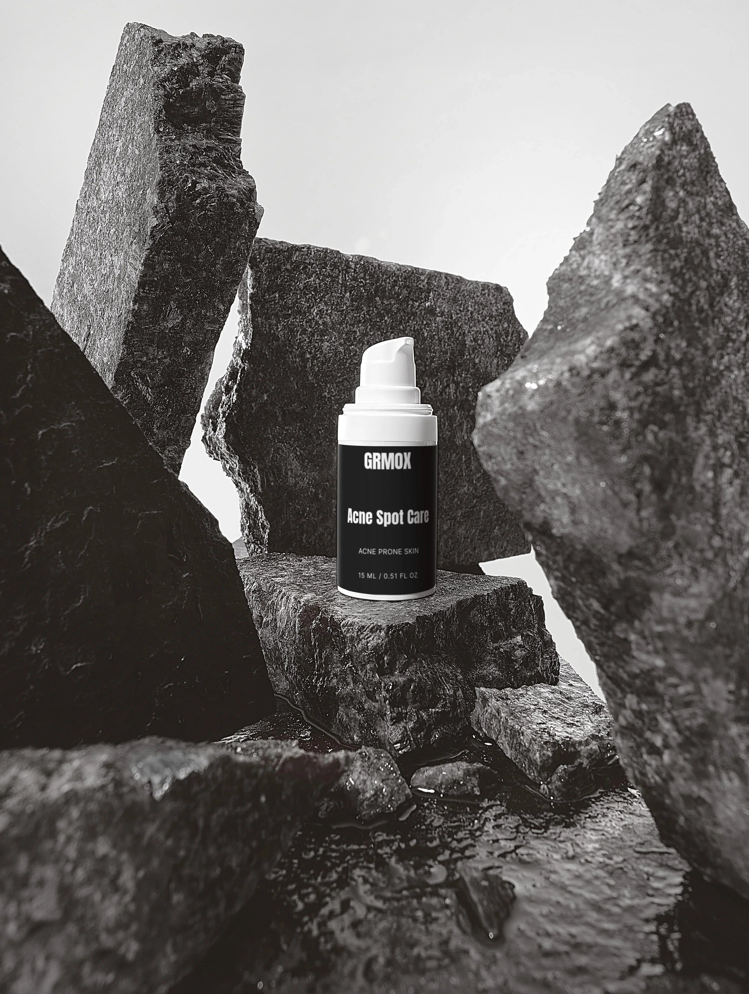 GRMOX Acne Spot Care for acne prone skin, 15ml bottle on rugged rocks, black and white